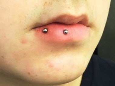 horizontal lip piercing on side
